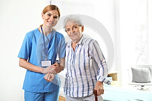 Nurse in uniform assisting elderly woman