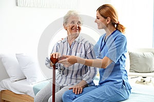 Nurse in uniform assisting elderly woman