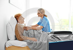Nurse in uniform assisting elderly woman