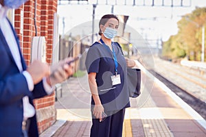 Nurse In Uniform On Railway Platform Wearing PPE Face Mask Commuting To Work During Pandemic