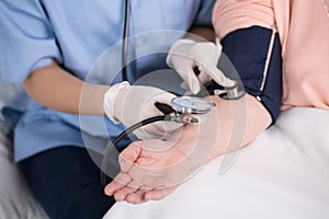 Nurse using blood pressure meter