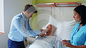 Nurse using digital tablet while doctor examining a patient