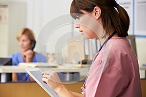 Nurse Using Digital Tablet At Nurses Station