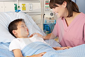 Nurse Visiting Child Patient On Ward photo