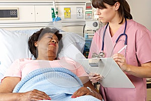 Nurse Visiting Senior Female Patient On Ward