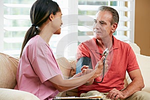 Nurse Visiting Senior Male Patient At Home