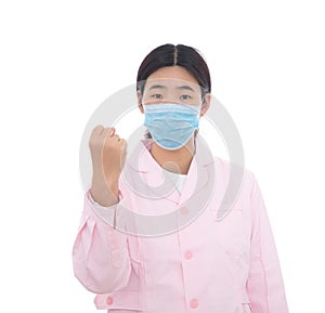 A nurse wearing a pink nurse uniform in front of a white background makes a cheering gestu