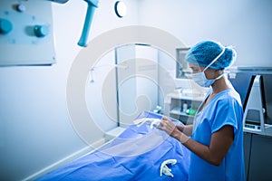 Nurse wearing surgical gloves in x-ray room