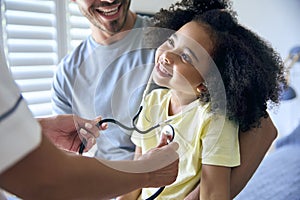 Nurse Wearing Uniform Listening To Girl Patient's Chest With Stethoscope In Private Hospital Room