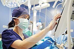 Nurse working with technology in operating room photo
