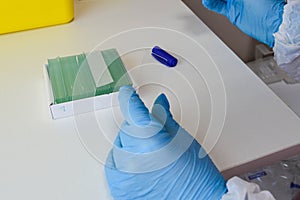 Nurse works with biological material. disposable glasses for the material are numbered and signed. PCR research, microbiology.