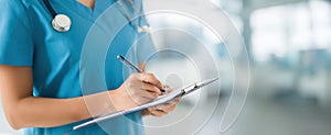 The nurse writes notes on a clipboard in a modern healthcare setting..AI generated image