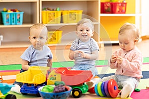 Nursery babies girl and boys playing together in a play room