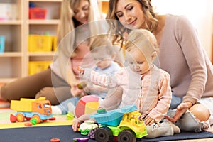 Nursery babies playing with adults in day care center