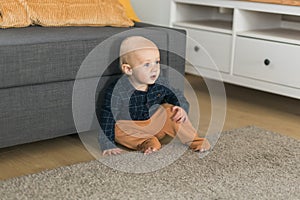 Nursery baby boy crawling on floor indoors at home copy space and empty space for text - Baby curiosity and child