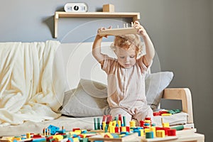 Nursery room filled with exploration. Building blocks of learning. Fun activities for young children. Funny wavy haired blonde