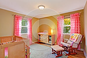 Nursery room with pink ruffle curtains photo
