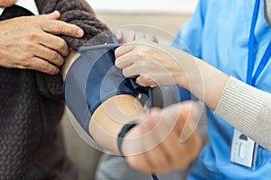 Nurses or caregivers take care of elderly by helping to check their blood pressure