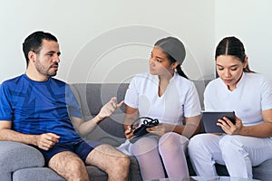 Nurses checking a man`s blood pressure at home