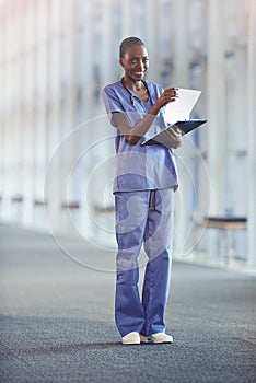 Nurses deliver quality and innovation in patient care. a young nurse holding a patient file in the hospital corridor.