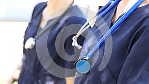 Nurses or doctors in blue scrubs with stethoscopes