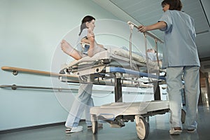 Nurses Moving Patient On Gurney In Hospital Corridor photo