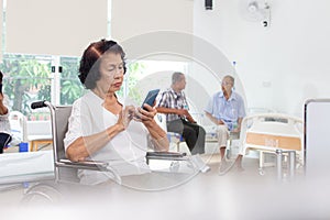 nursing home care concept. Elderly Woman Using A Mobile Telephone. looking at camera.