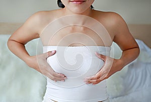 Nursing mother examines her breasts. Strong women`s breasts health