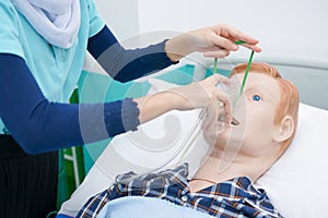 Nursing student are practicing how to provide oxygen administration to the patient by a doll of patient in the simulation of virt