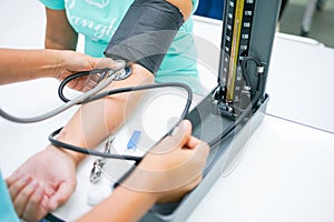 Nursing students are training measurement of blood pressure with manual sphygmomanometer and stethoscope at nursing school.
