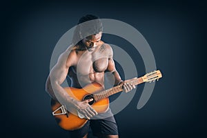 Nuscular topless young black man playing guitar