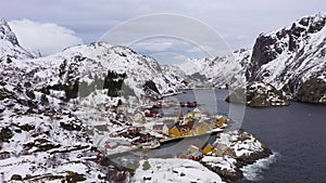 Nusfjord Fishing Village and Mountains in Winter. Lofoten Islands, Norway. Aerial View