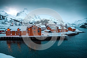 Nusfjord, small fishing village in Norway, lofoten, during amazing winter evening, ships, snow and yellow cabins.