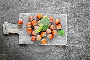 Nut abundance. Hazelnuts on a gray wooden board on a gray slate background. Fresh harvest of hazelnuts. Farmed organic