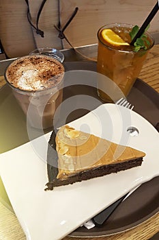 Nut chocolate cake with milk chocolate drink in cafe. Mobile photography