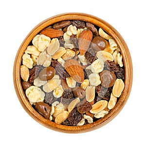 Nut chocolate mix, sweet snack food, in a wooden bowl, close up