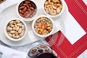 Nut set. Greek mix of nuts. pistachios, almonds, cashews. Glass of red wine. Place for text