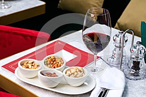 Nut set. Greek mix of nuts. pistachios, almonds, cashews. Glass of red wine. Place for text