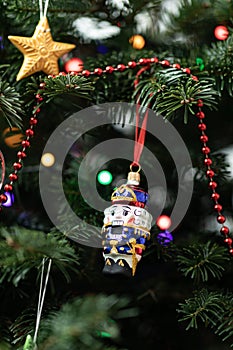 The nutcracker on a fir-tree. Christmas decoration of a fir-tree. New Year`s background