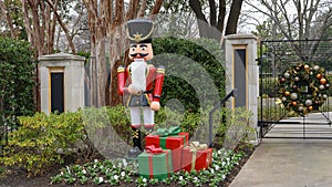 Nutcracker standing guard protecting a house in Dallas, Texas, with gifts at his feet.