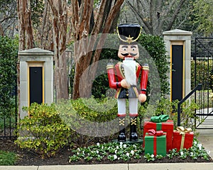 Nutcracker standing guard protecting a house in Dallas, Texas, with gifts at his feet.