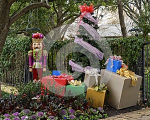 Nutcracker beside a tree surrounded by gifts standing guard protecting a house in Dallas, Texas