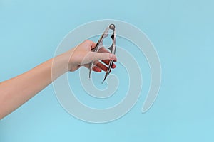 Nutcracker in woman's hand on blue background