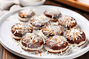 nutella bruschetta sprinkled with desiccated coconut, served on a round white plate