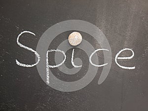 A nutmeg dotting the i on the word spice on a blackboard