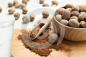 Nutmeg powder and seeds on wooden board