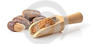 Nutmeg powder in wood scoop on white background