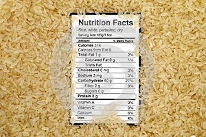 Nutrition facts of dry white parboiled rice with rices background