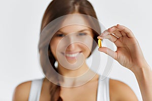 Nutrition. Healthy Lifestyle. Woman Holding Pill With Fish Oil O