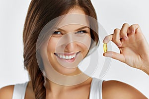 Nutrition. Healthy Lifestyle. Woman Holding Pill With Fish Oil O